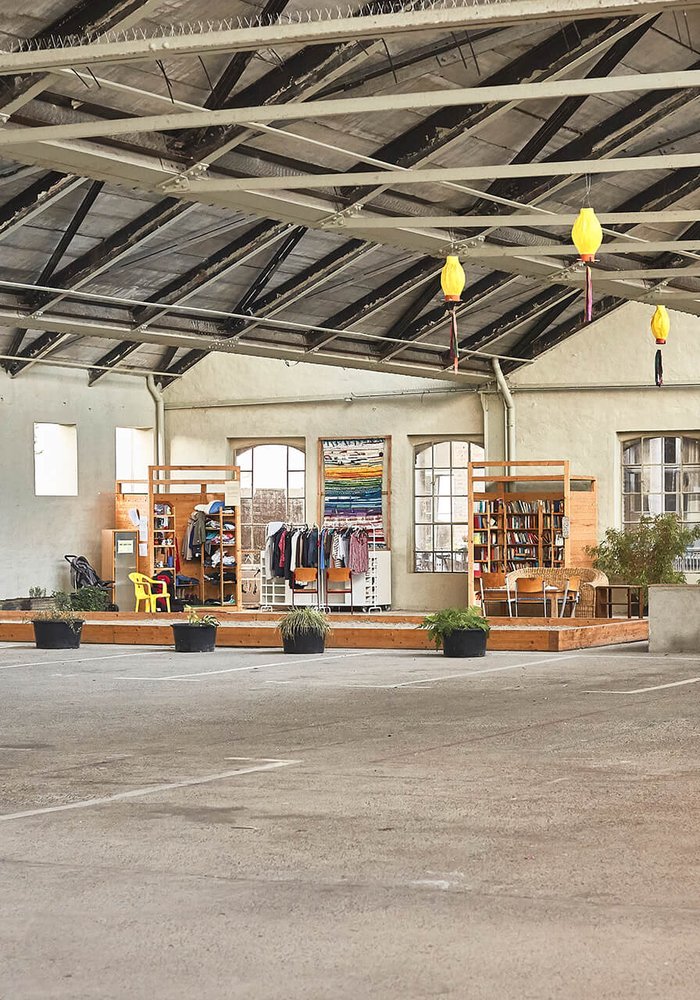 Die Shedhallen von innen, in der eine kleine Ecke voller Regale zu sehen ist.