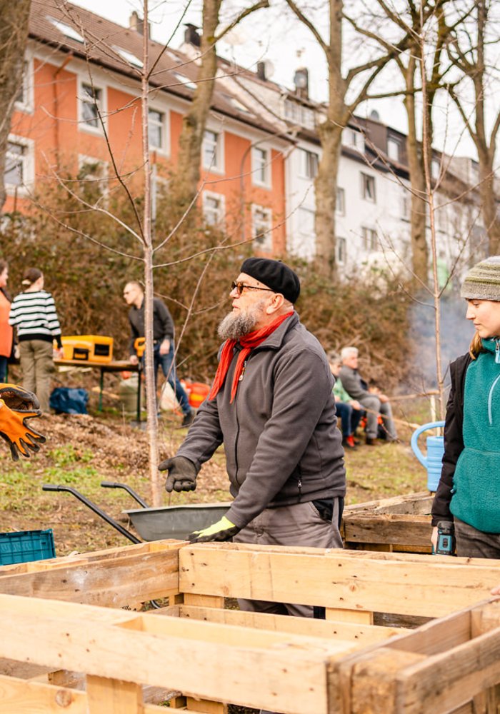 Menschen unterhalten sich an einem Hochbeet am HONSWERK