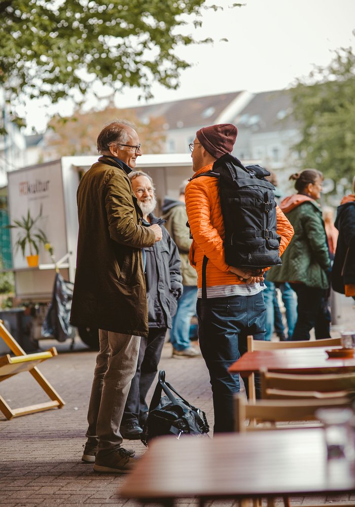Zwei Menschen auf einem Platz, die sich unterhalten.