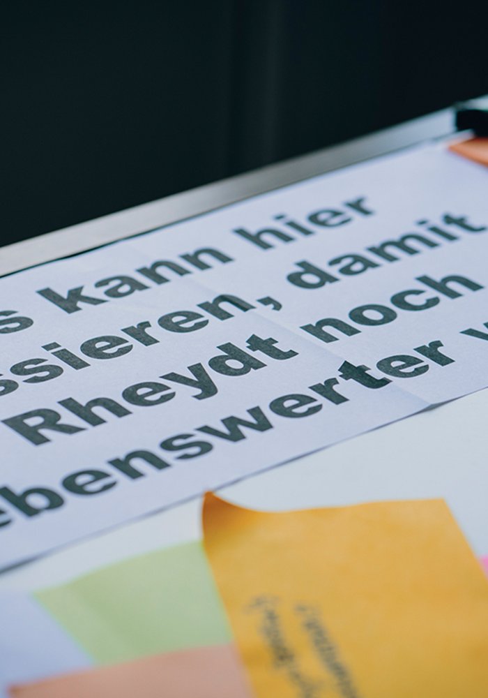 Ein Blatt mit Post Its auf dem steht "Was kann hier passieren, damit Rheydt noch lebenswerter wird?"