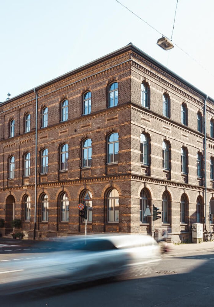 Außenansicht auf die Samtweberei von der Straße aus. Man sieht die Fassade mit vielen Fenstern.